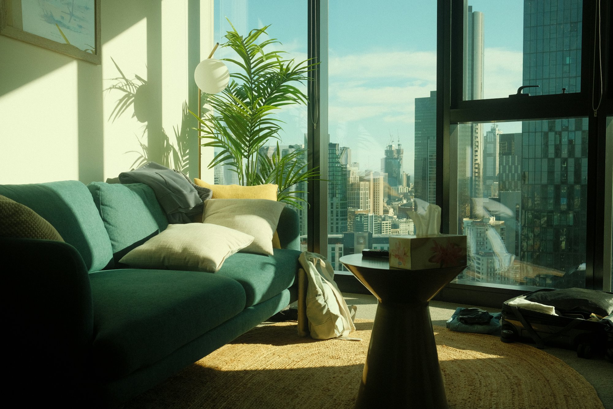 A green sofa in a condo living room with city views