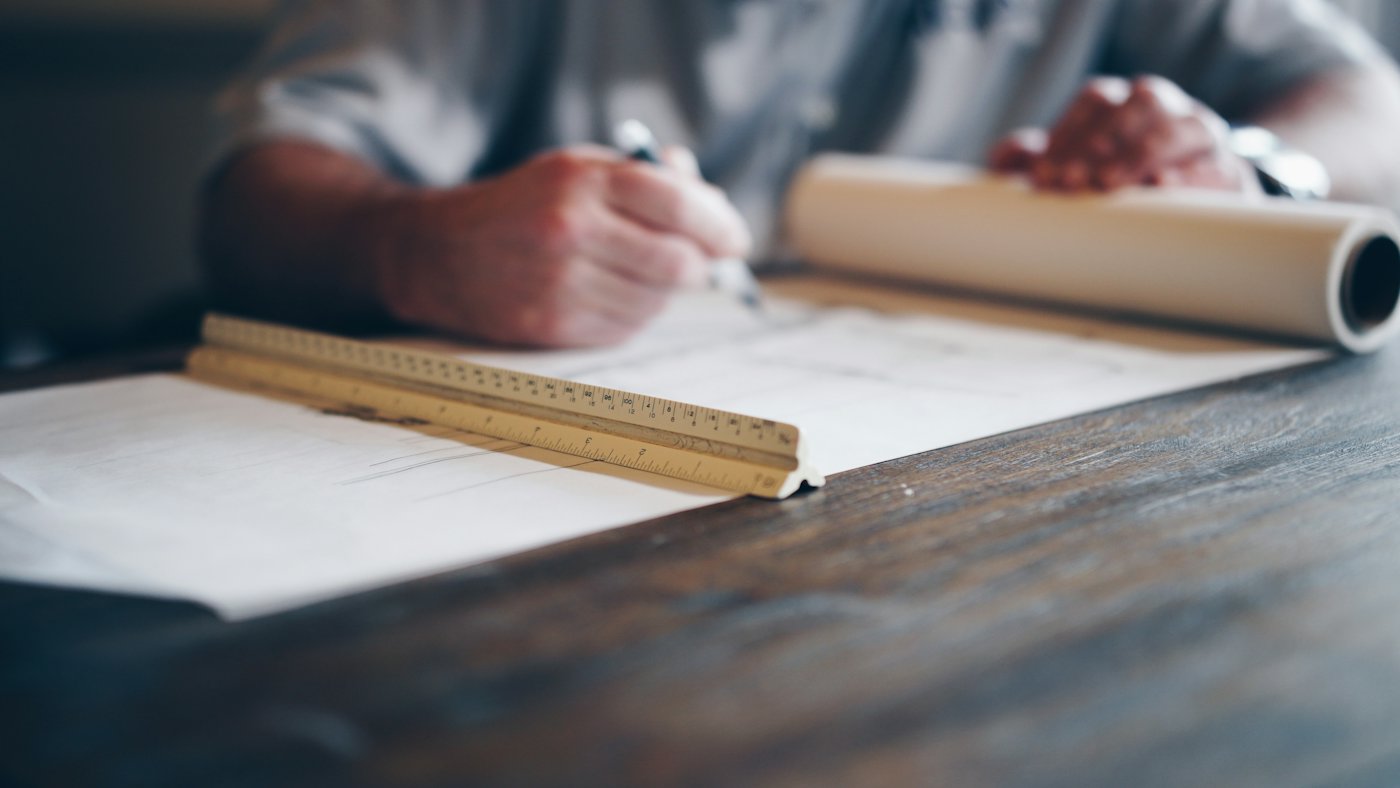 A designer's hands sketching a floor plan